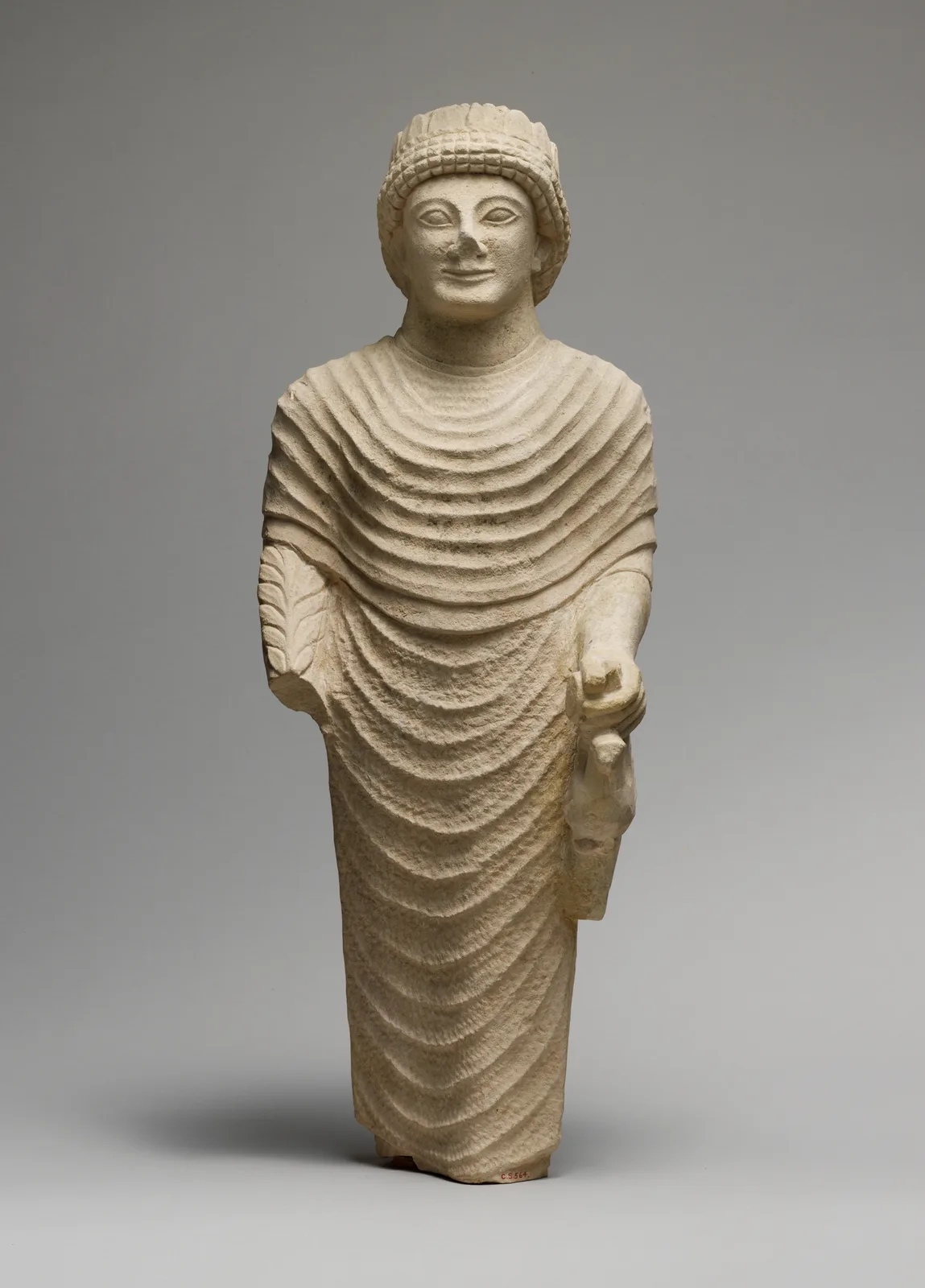 Limestone statue of a male votary holding a bird in the left hand